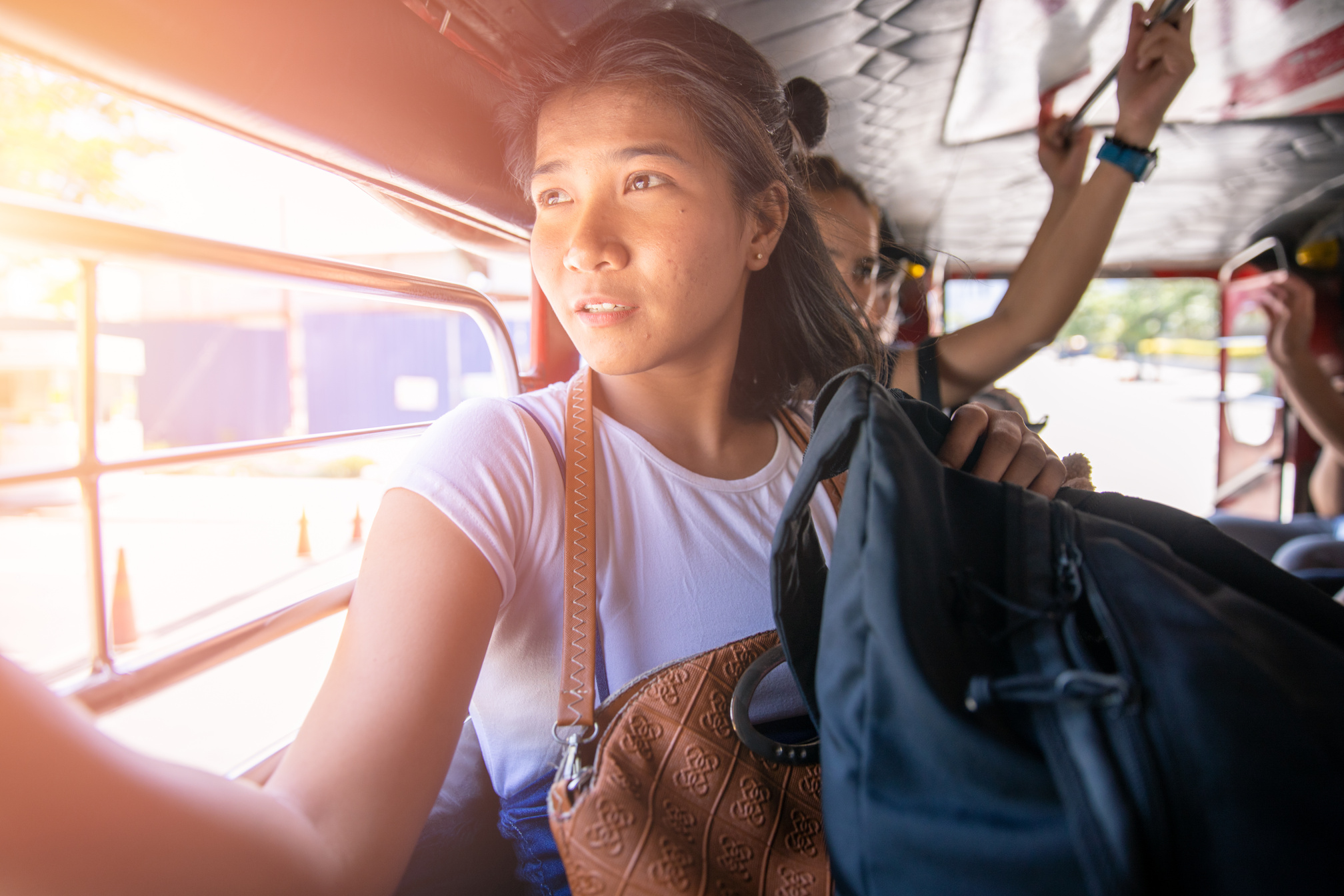 Young Filipino woman traveling by jeepney